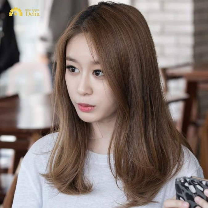 Cô gái với mái tóc duỗi thẳng tự nhiên, kết hợp màu nhuộm thời thượng, là một kiểu tóc nữ năm 2024 được yêu thích.