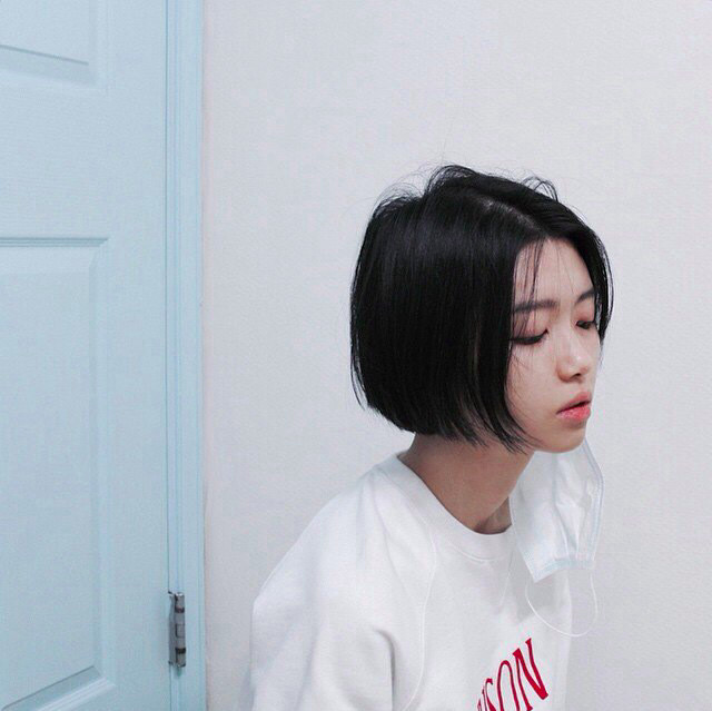 Cô gái với mái tóc ngắn đen được tạo kiểu phồng nhẹ ở phần đuôi, khuôn mặt rạng rỡ, toát lên vẻ năng động, tươi mới.
