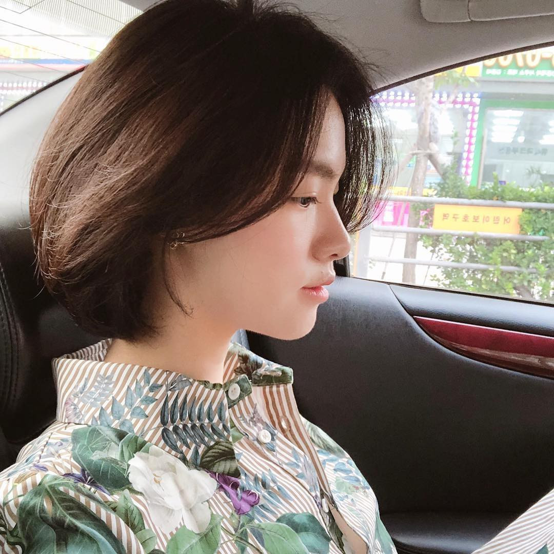 Cô gái với mái tóc ngắn đen tém, phần mái được vuốt sang một bên, gương mặt sắc sảo, thể hiện vẻ đẹp mạnh mẽ, cá tính.