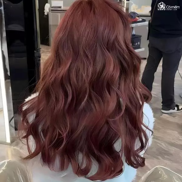 Kiểu tóc tiệc cho mặt tròn với mái tóc dài uốn xoăn sóng lớn tạo hiệu ứng che phủ hai bên má