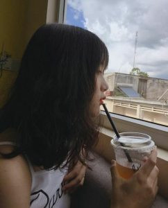 Mái tóc ngắn layer tinh tế của cô gái, phần mái buông lơi che một phần khuôn mặt