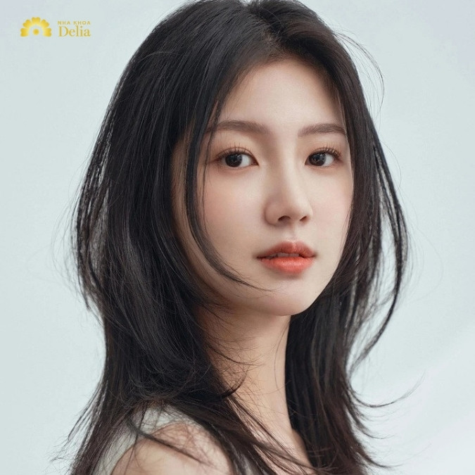 Mẫu tóc uốn cụp layer giúp gương mặt tròn trở nên thon gọn hơn, là xu hướng kiểu tóc nữ năm 2024.