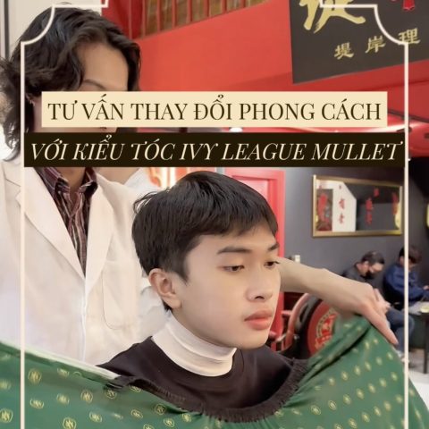 Một người đàn ông với kiểu tóc Ivy League Mullet lịch lãm, phần mái được vuốt gọn gàng và gáy được giữ dài nhẹ nhàng