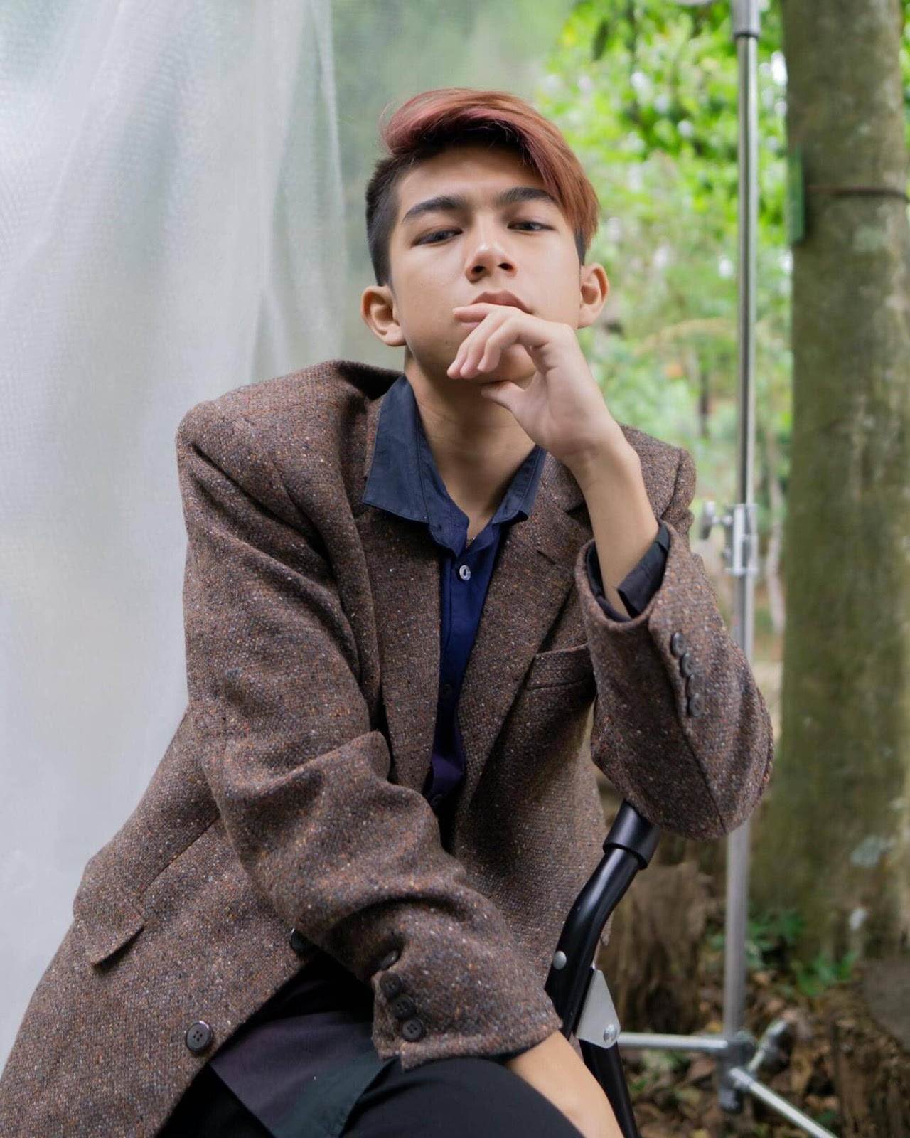 người đàn ông mặc áo khoác nâu với mái tóc màu nâu vàng