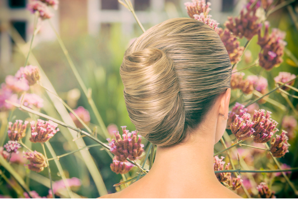 Người mẫu nữ với tóc búi phồng cao, phù hợp trang phục trễ vai dự tiệc