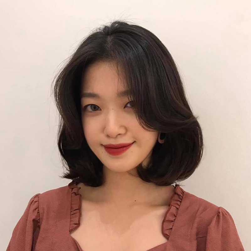 Phụ nữ trung niên rạng rỡ với tóc ngắn uốn cụp tự nhiên