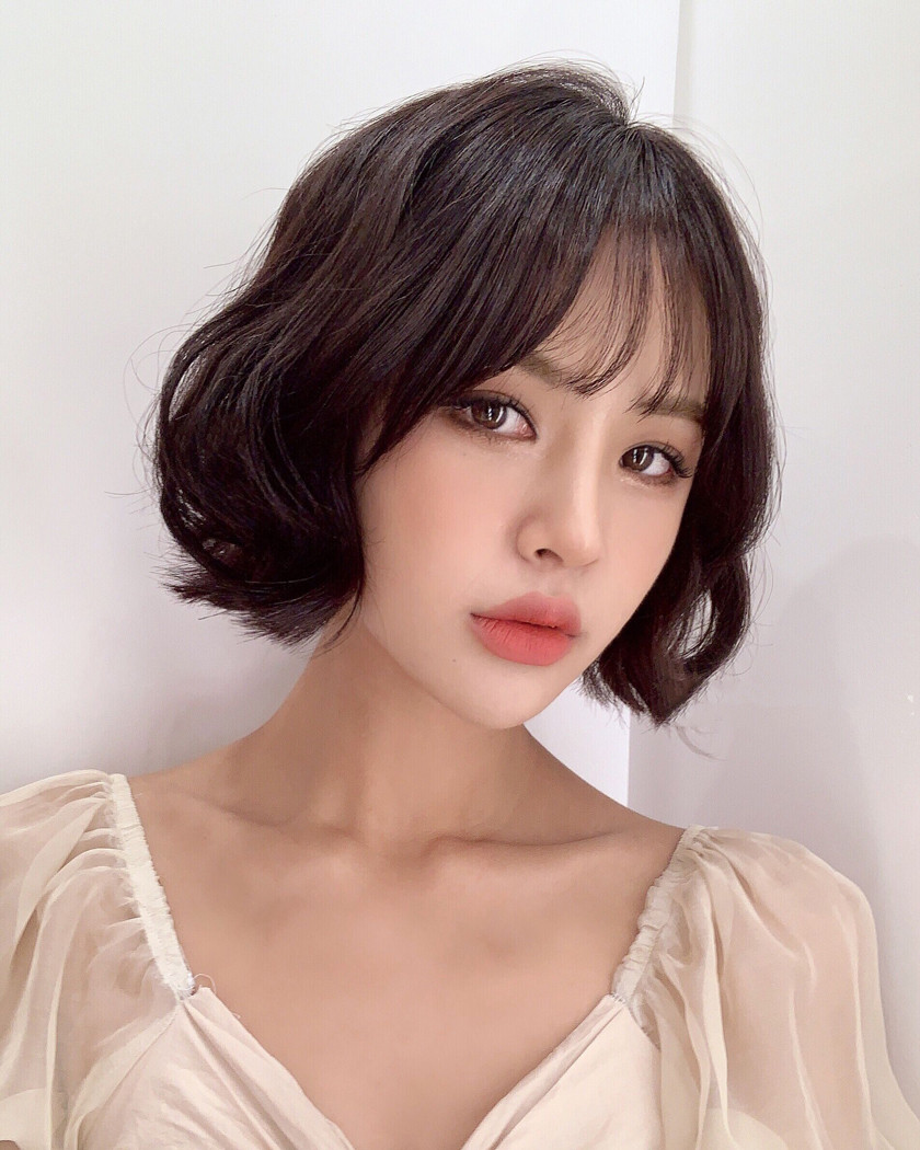 Tóc midi uốn xoăn nhẹ nhàng che khuyết điểm mặt tròn