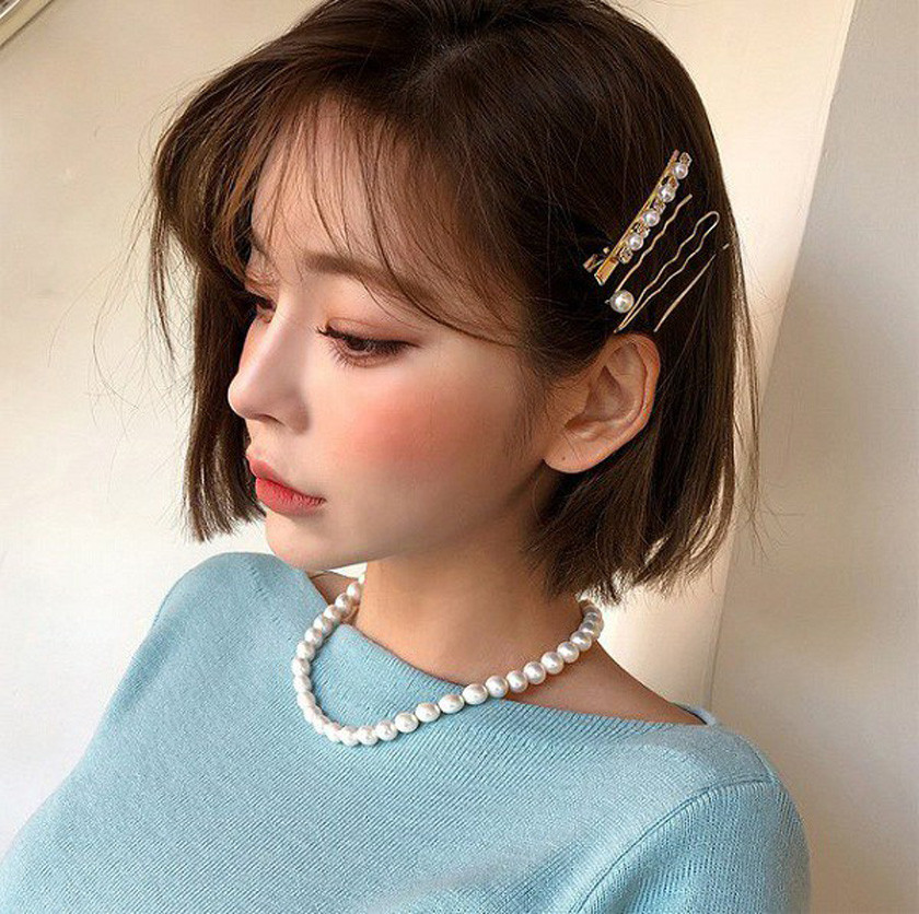 Tóc ngắn bob với kẹp tóc tiểu thư màu trắng, tạo điểm nhấn ngọt ngào cho mái tóc ngắn đi tiệc.