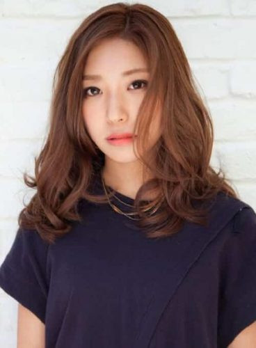 Tóc xoăn đuôi mái lệch làm thon gọn mặt gò má cao