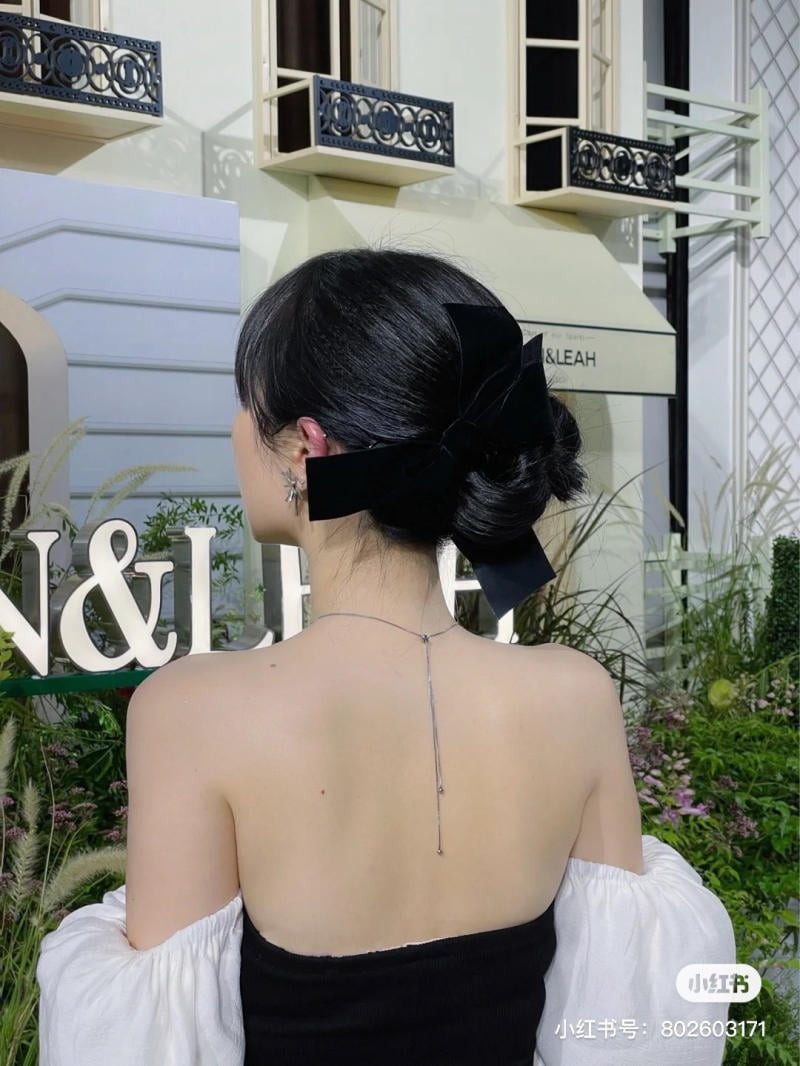 Mô tả ảnh: Kiểu tóc búi nơ lớn ngọt ngào, thích hợp với trang phục hở lưng